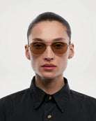 Pantos Gold Sunglasses worn by a model, showcasing the stylish design with brown lenses and unisex appeal.