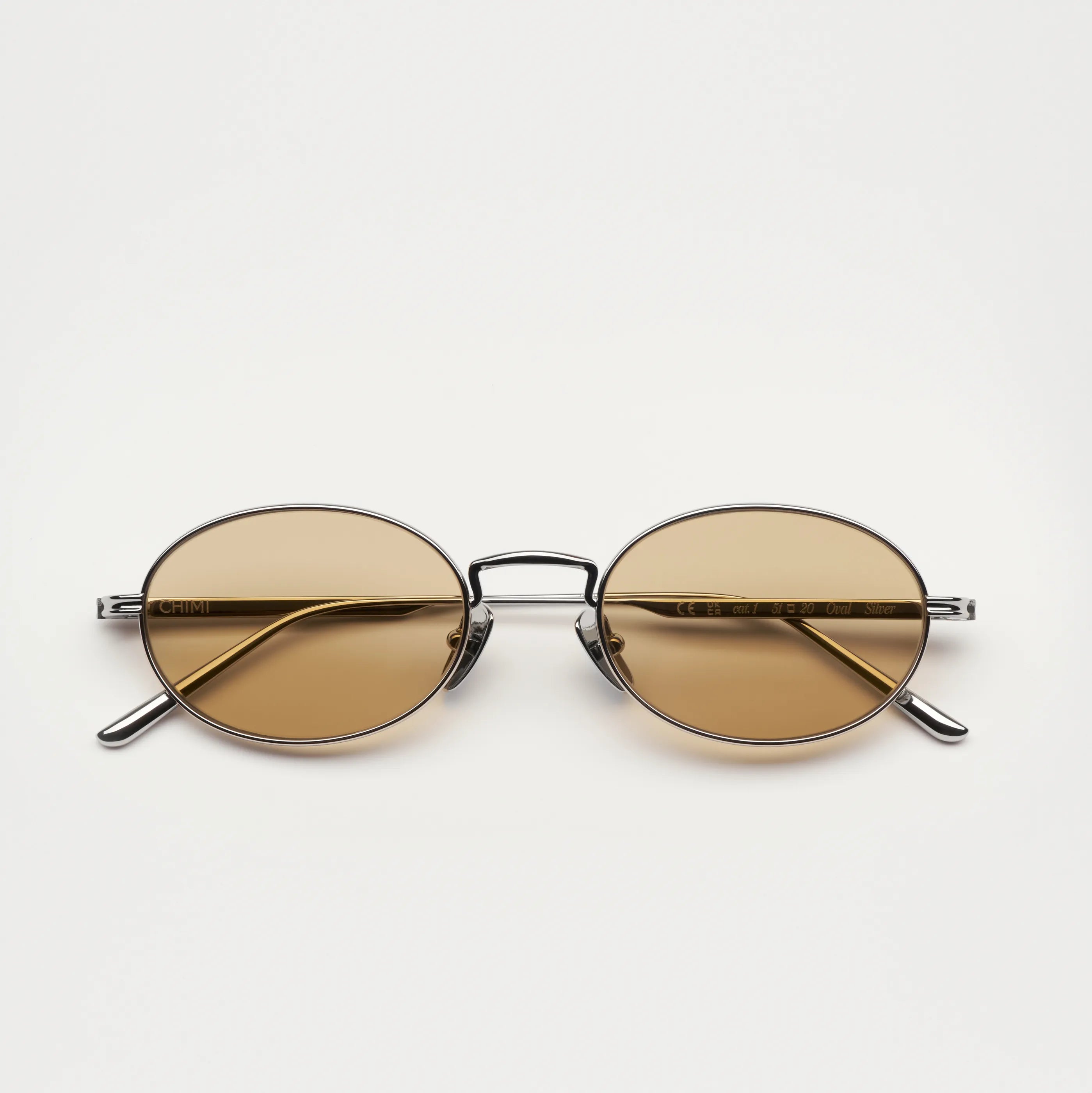 Oval Silver Sunglasses with brown lenses, UV protection, and bio nylon frame against a neutral background.