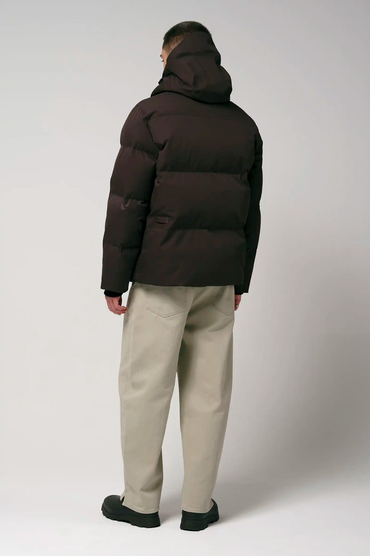 Model wearing the Bayu Black Coffee Coat, showcasing the back view of the waterproof puffer jacket in dark brown.