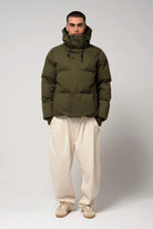 Model wearing the Bayu Dark Olive Green Coat, a waterproof and windproof puffer jacket with biodegradable insulation.