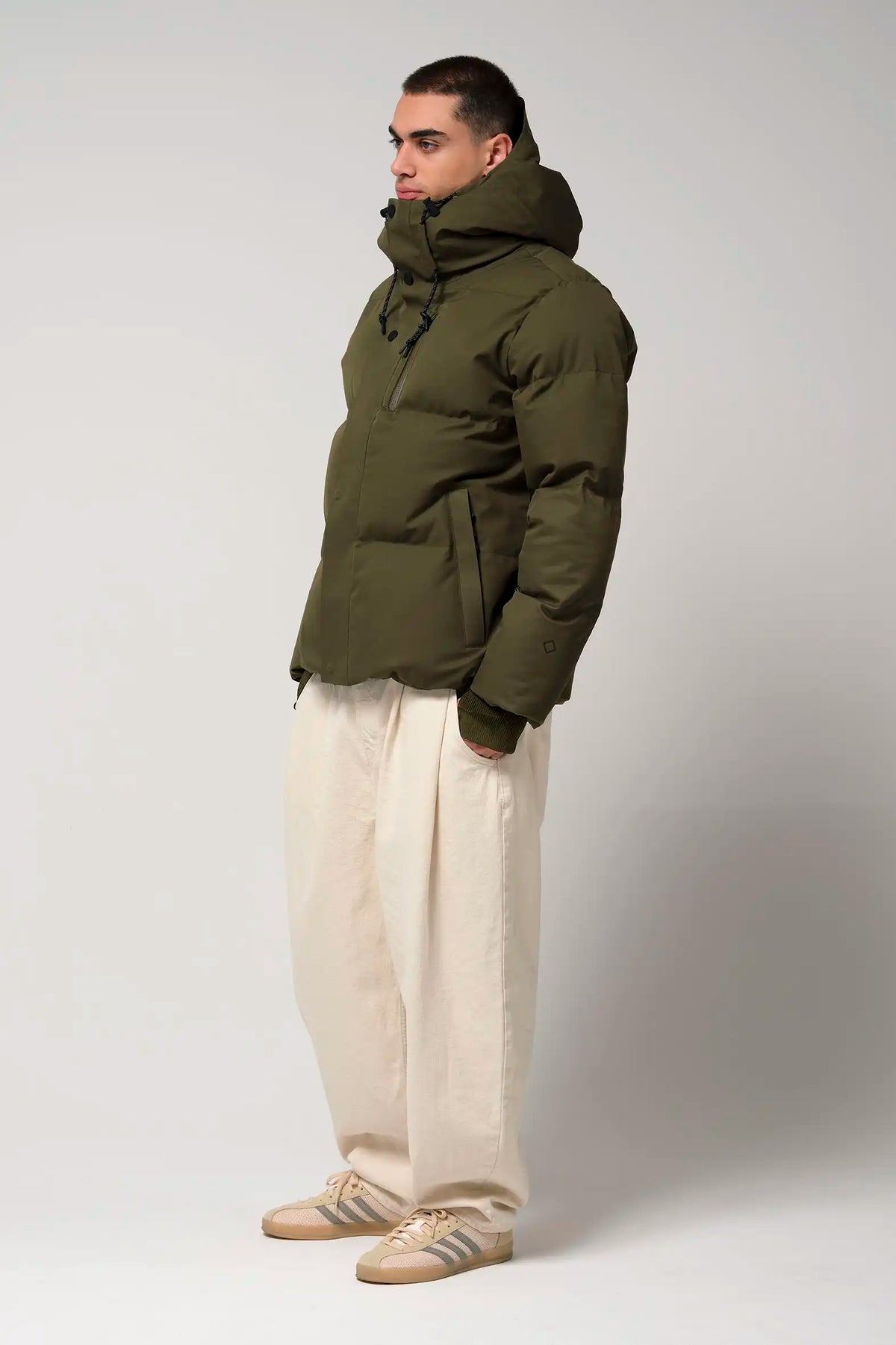 Model in Bayu Dark Olive Green Coat, showcasing its waterproof and breathable features.
