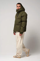 Bayu Dark Olive Green Coat worn by a model, showcasing waterproof, breathable, and windproof features.