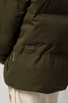Bayu Dark Olive Green Coat close-up showing cuff and pocket details, perfect for outdoor activities.