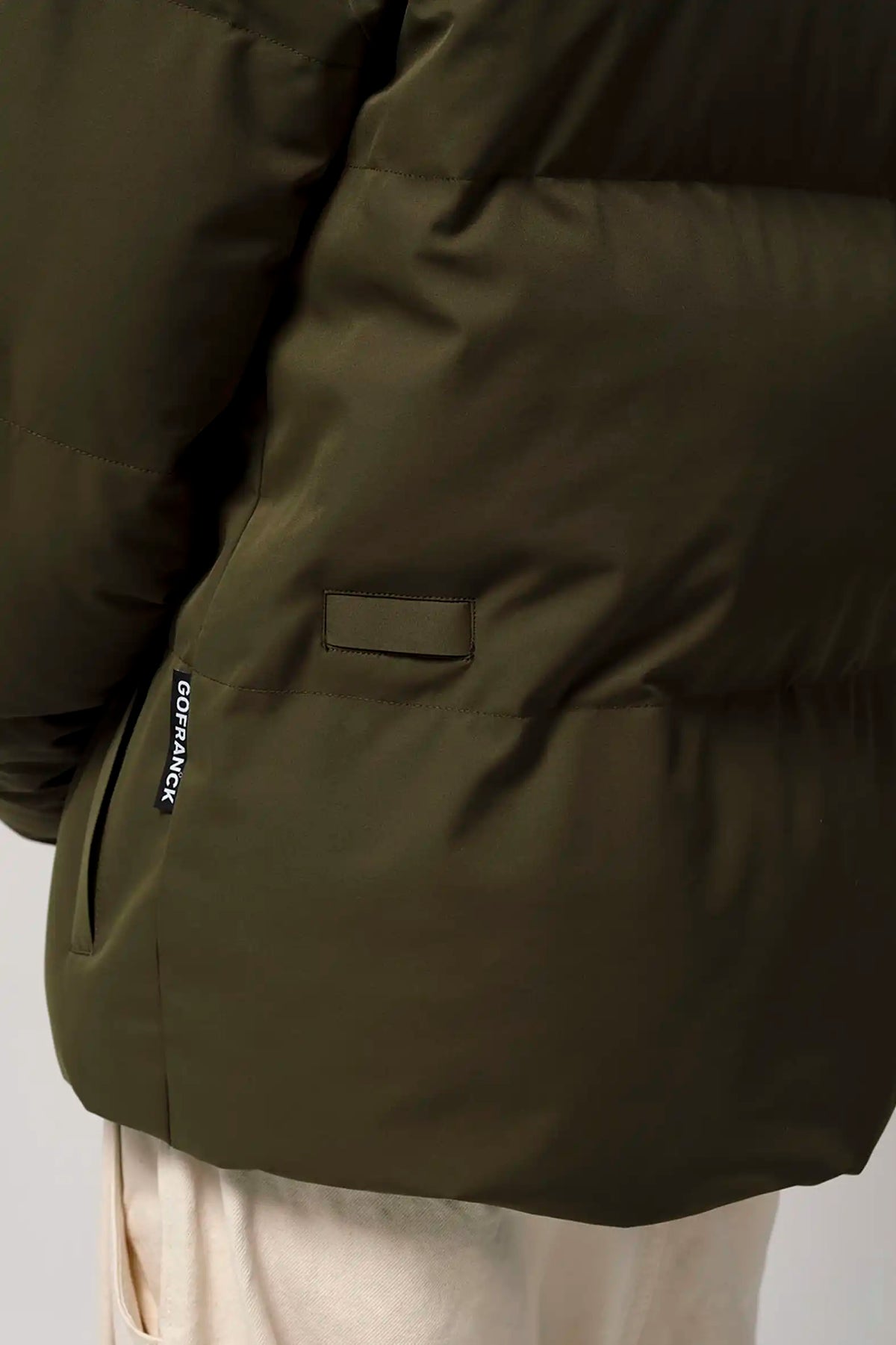 Bayu Dark Olive Green Coat close-up showing cuff and pocket details, perfect for outdoor activities.