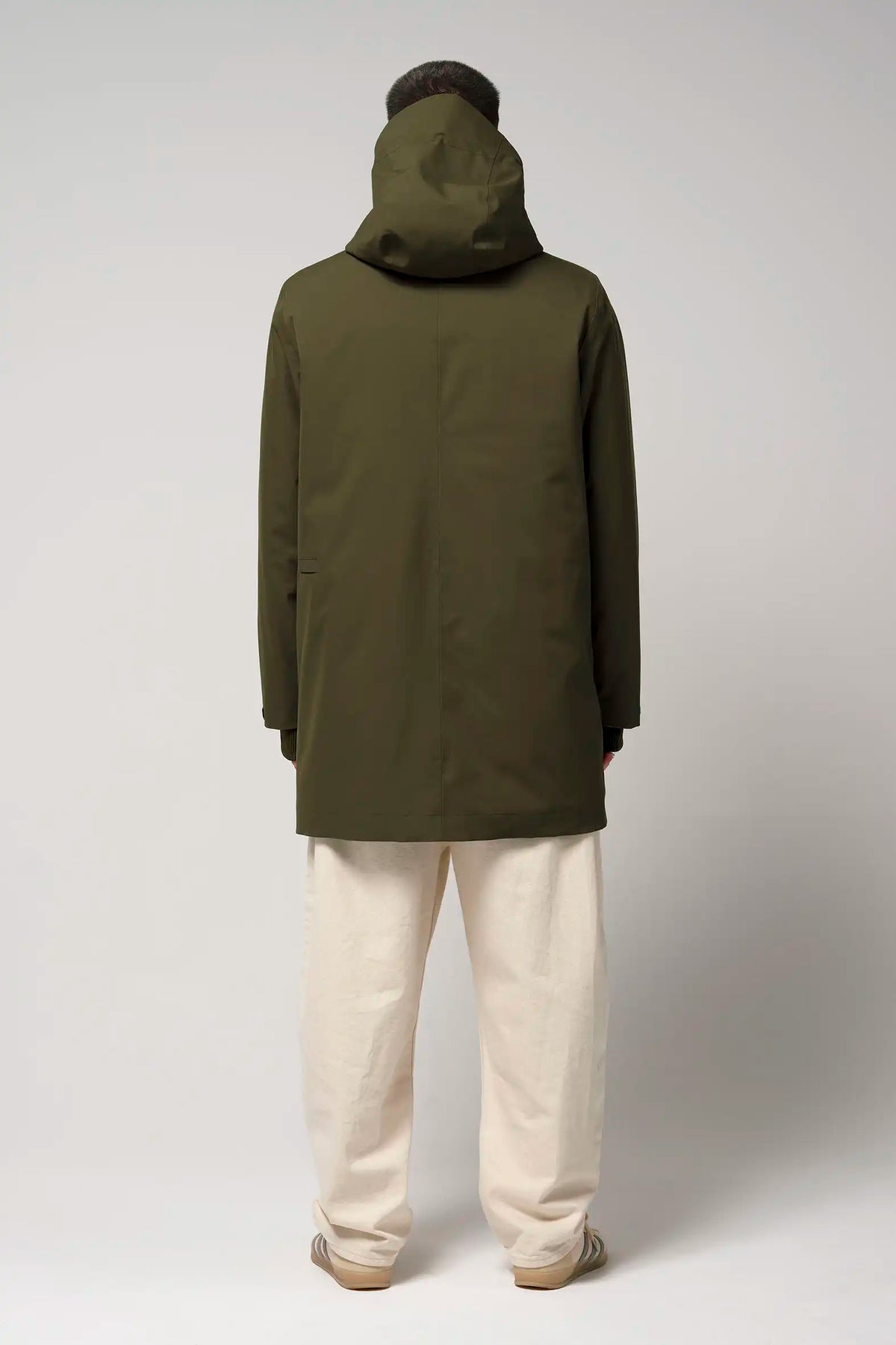 Model wearing the Cielo Dark Olive Green Coat from the back, showcasing its waterproof fabric and hood.