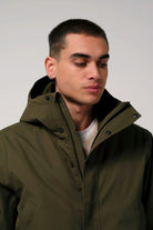 Cielo Dark Olive Green Coat worn by model with hood and two-way zipper, showcasing waterproof and breathable features.