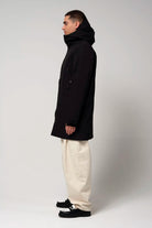 Cielo Deep Black Coat modeled by a man wearing it from the side, showcasing its waterproof and windproof features.