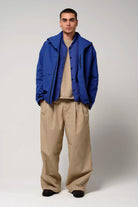 Claud Sodalite Blue Coat worn with baggy tan pants, showcasing a stylish 3-in-1 waterproof jacket.