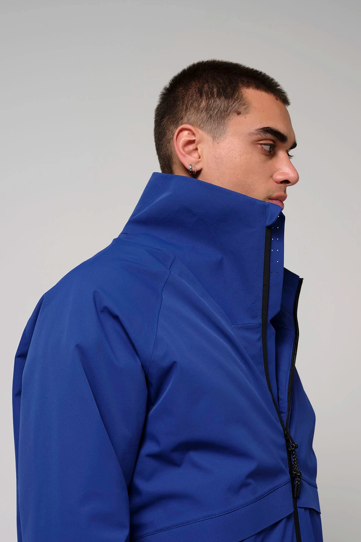 Profile view of a man wearing the Claud Sodalite Blue Coat, showcasing its vibrant blue color and high collar design.