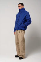 Model wearing Claud Sodalite Blue Coat, a waterproof and windproof 3-in-1 jacket, styled with beige pants.