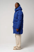 Model wearing Climate Sodalite Blue Coat, showcasing waterproof and breathable features in a stylish design.