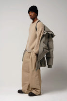 Model wearing Climate Timber Wolf Grey Coat with beige sweater and wide pants.