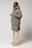 Model wearing Climate Timber Wolf Grey Coat, featuring side zippers and multiple pockets.