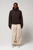 Model wearing Guthrie Black Coffee Coat, a waterproof and windproof jacket, styled with beige pants.