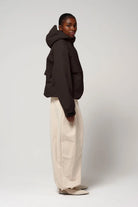 Model wearing the Guthrie Black Coffee Coat, showcasing its stylish and waterproof design with an adjustable hood.