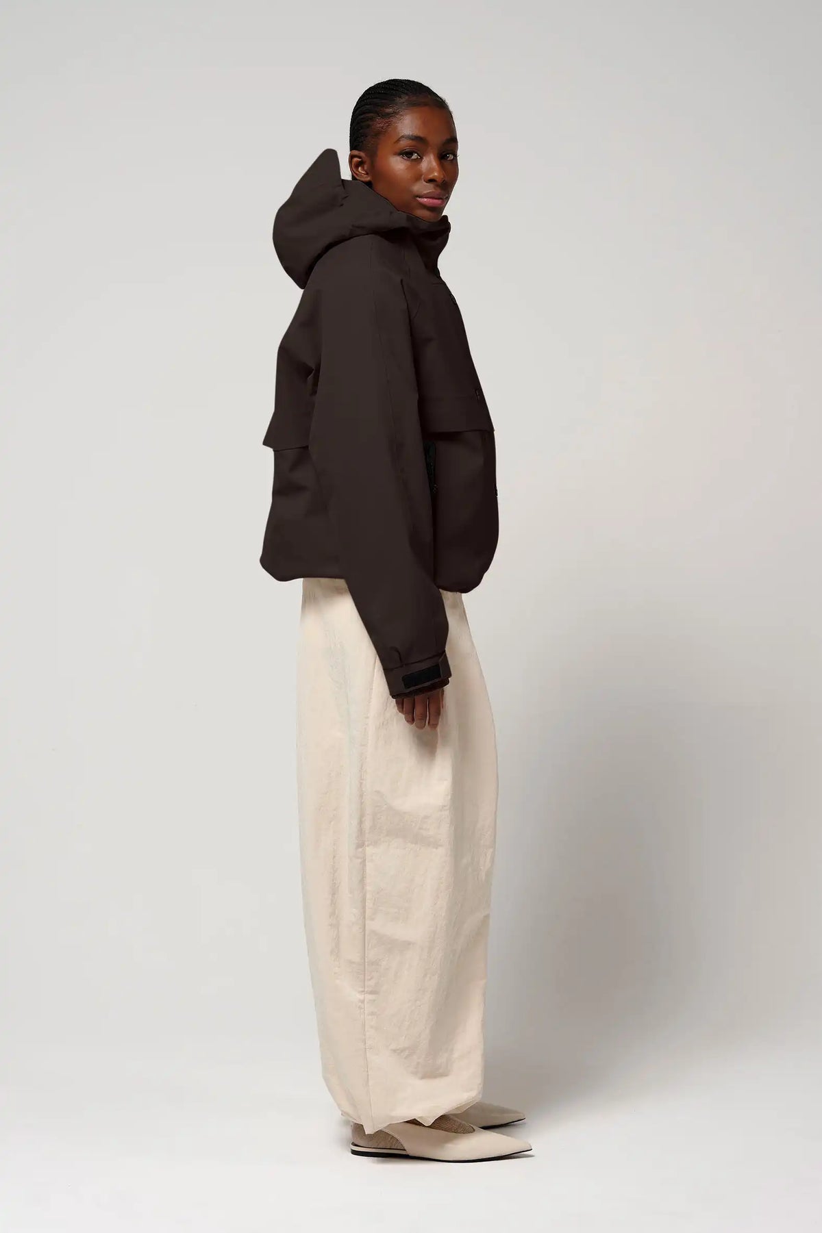 Model wearing the Guthrie Black Coffee Coat, showcasing its stylish and waterproof design with an adjustable hood.