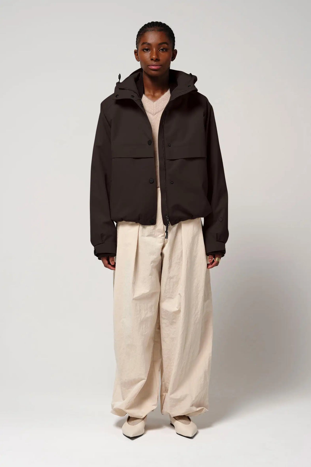 Model wearing the Guthrie Black Coffee Coat, a waterproof and breathable jacket, paired with wide trousers.