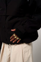Close-up of the Guthrie Deep Black Coat showcasing adjustable cuffs and stylish rings.