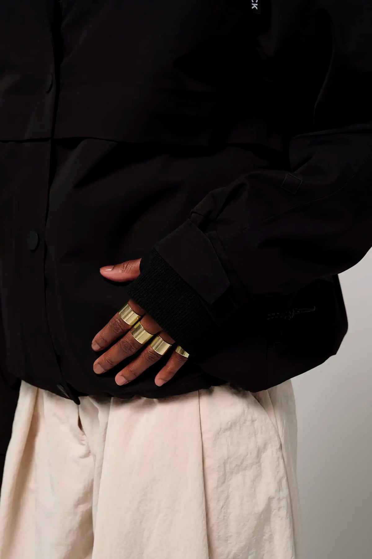 Close-up of the Guthrie Deep Black Coat showcasing adjustable cuffs and stylish rings.