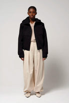 Guthrie Deep Black Coat worn by a model with a layered outfit, showcasing its stylish design and practical features.