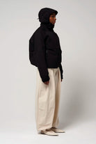 Guthrie Deep Black Coat showcasing waterproof and windproof features with an adjustable hood and two outer pockets.