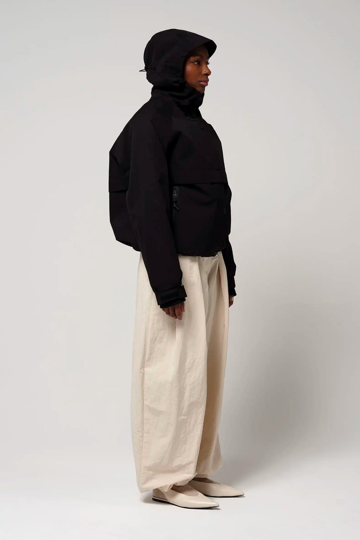 Guthrie Deep Black Coat showcasing waterproof and windproof features with an adjustable hood and two outer pockets.