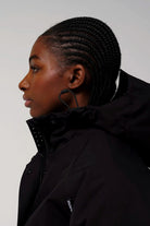 Guthrie Deep Black Coat modeled by a woman, showcasing the adjustable hood and sleek design.