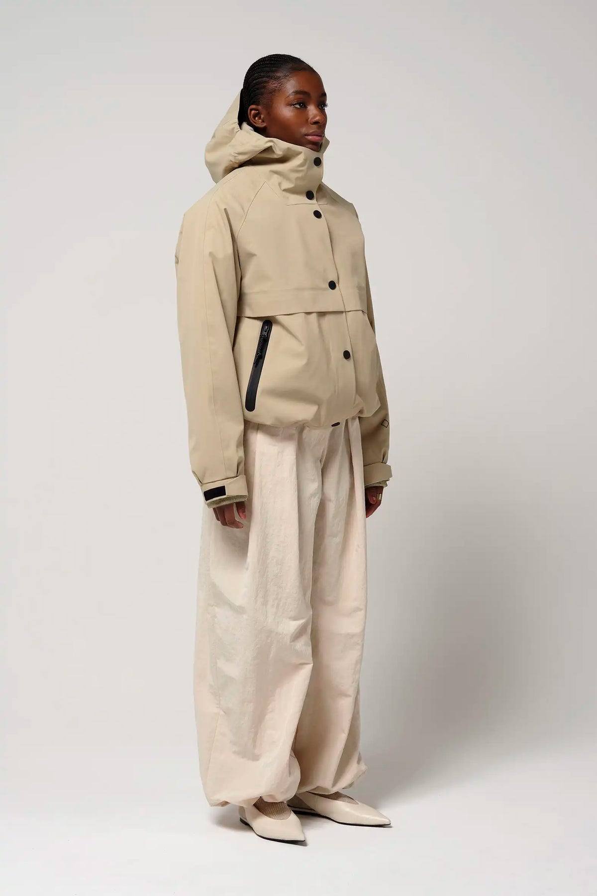 Guthrie Fields of Rye Beige Coat displayed on model, showcasing waterproof, breathable, and windproof features.