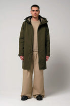 Raiden Dark Olive Green Parka worn by a model, showcasing its waterproof, breathable design and adjustable hood.