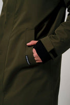 Person wearing the Raiden Dark Olive Green Parka, showcasing the pocket and cuff design.