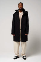 Man wearing Raiden Deep Black Parka, a waterproof and breathable coat ideal for cold and rainy weather.