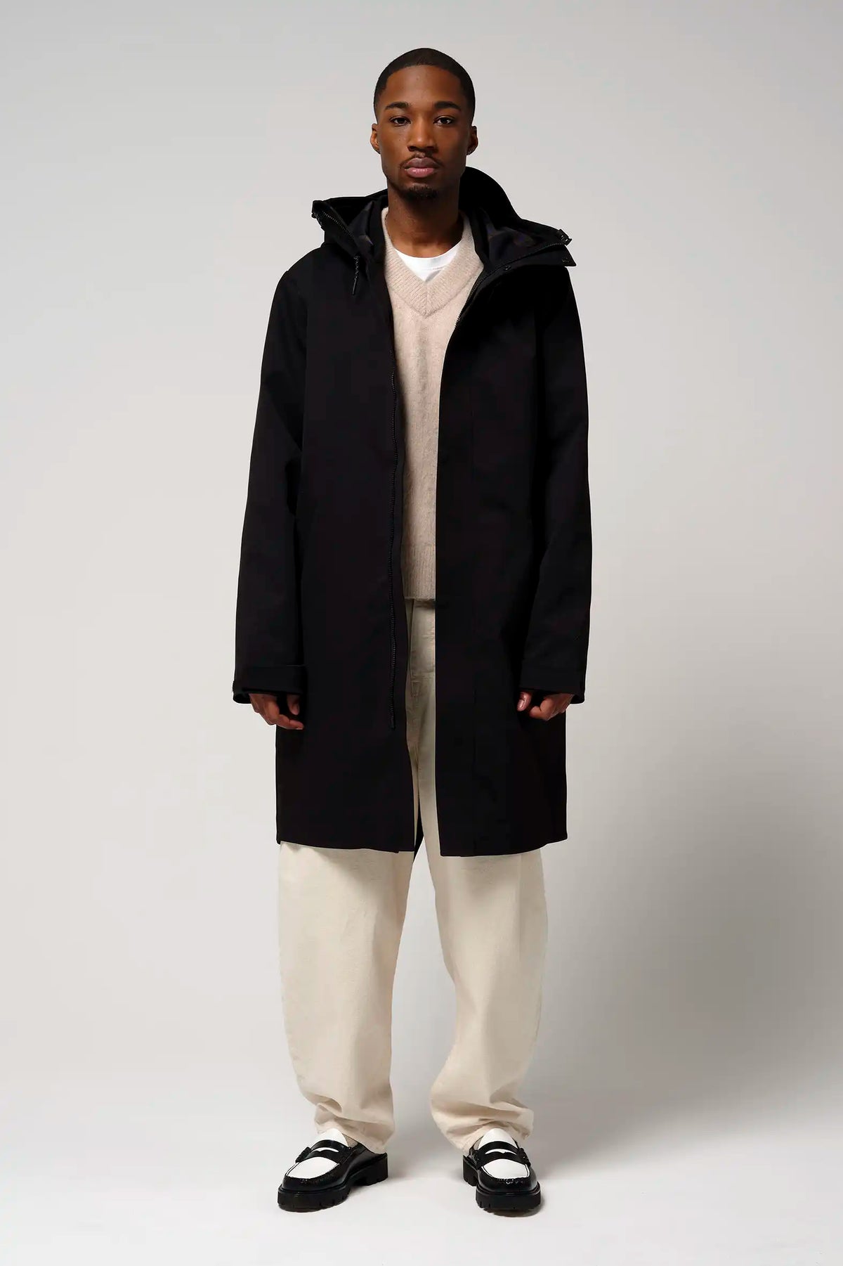 Man wearing Raiden Deep Black Parka, a waterproof and breathable coat ideal for cold and rainy weather.