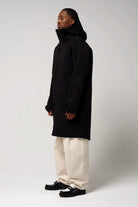 Model wearing Raiden Deep Black Parka, showcasing its waterproof and windproof features in a stylish black design.