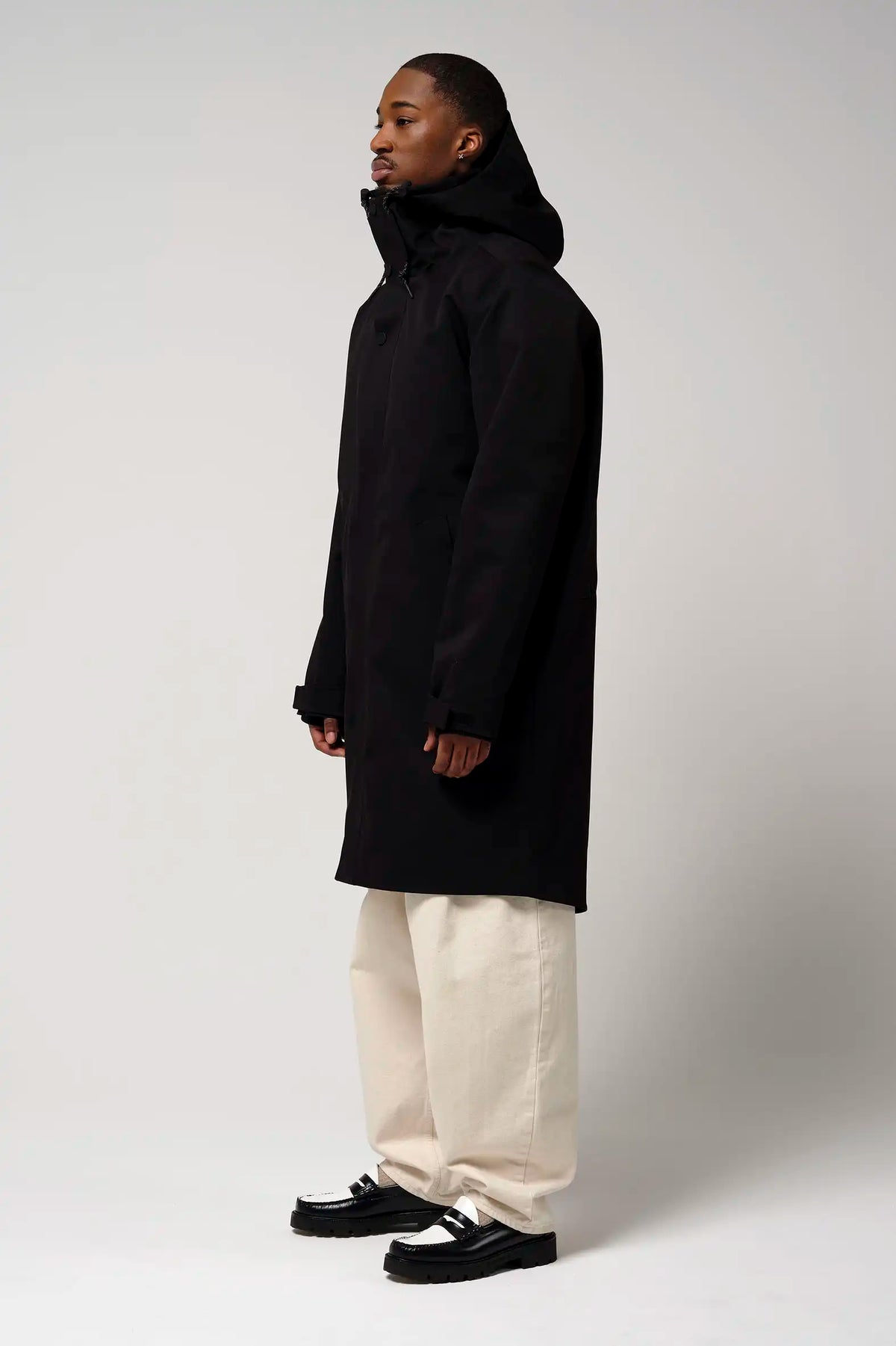 Model wearing Raiden Deep Black Parka, showcasing its waterproof and windproof features in a stylish black design.