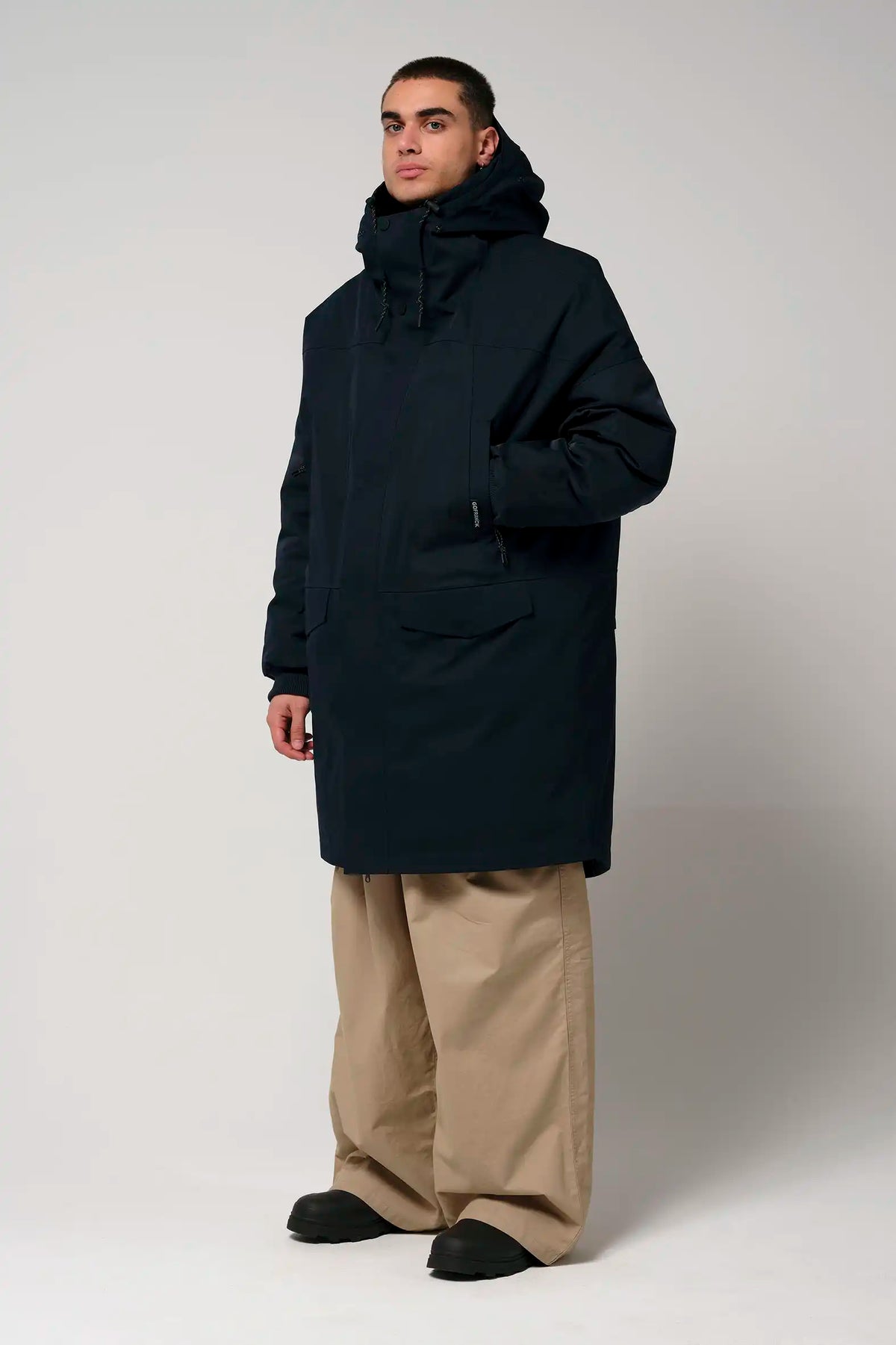 Stratus Sky Captain Blue Parka shown on model, featuring a hood and pockets, perfect for rainy and cold weather.