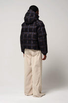 Person wearing Talon Blue Tartan Check Coat, showcasing back view and adjustable hood with plaid design.