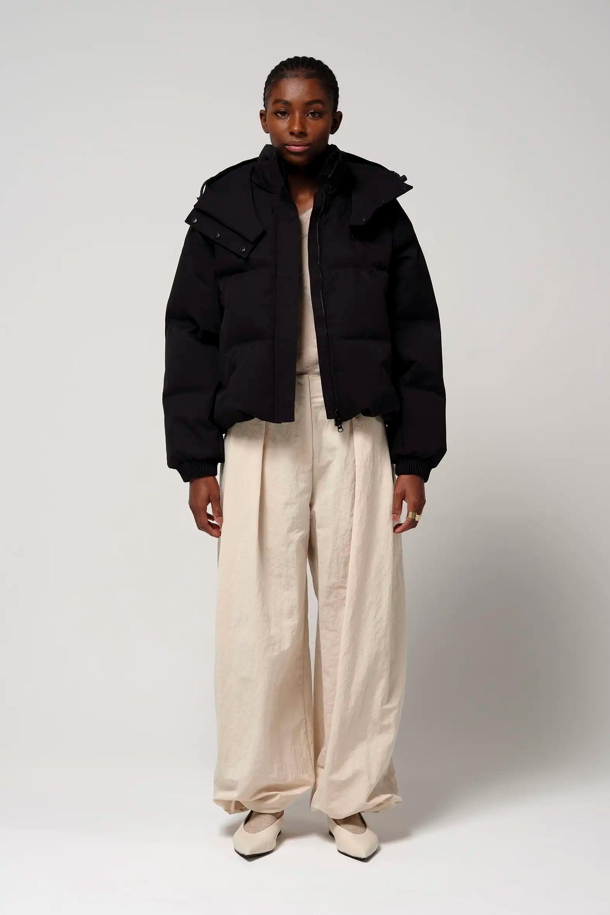 Model wearing Talon Deep Black Coat with stylish beige pants, showcasing modern urban outerwear.