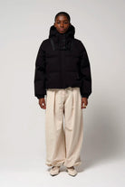Model wearing the Talon Deep Black Coat with hood, showcasing its stylish design and functionality.