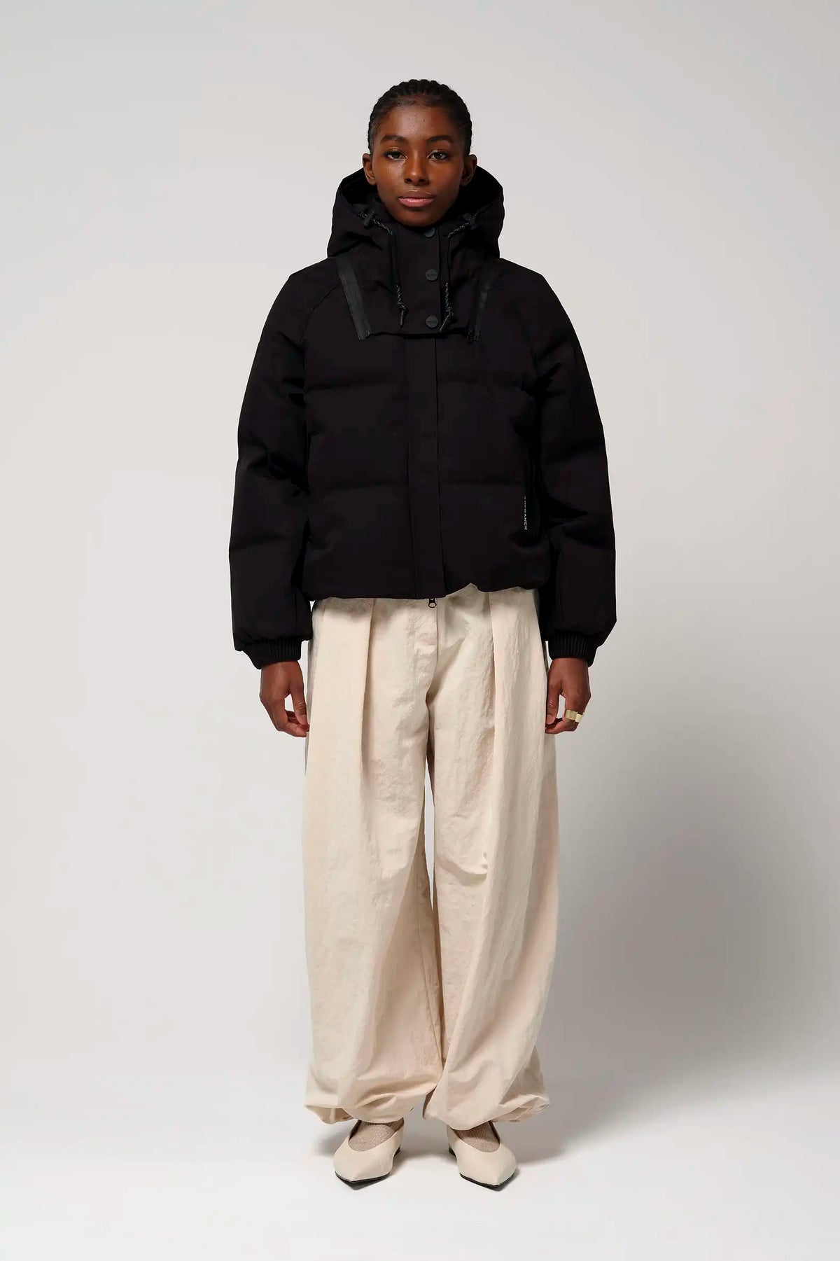 Model wearing the Talon Deep Black Coat with hood, showcasing its stylish design and functionality.