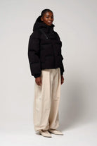 Model wearing Talon Deep Black Coat with removable hood and two-way zipper.