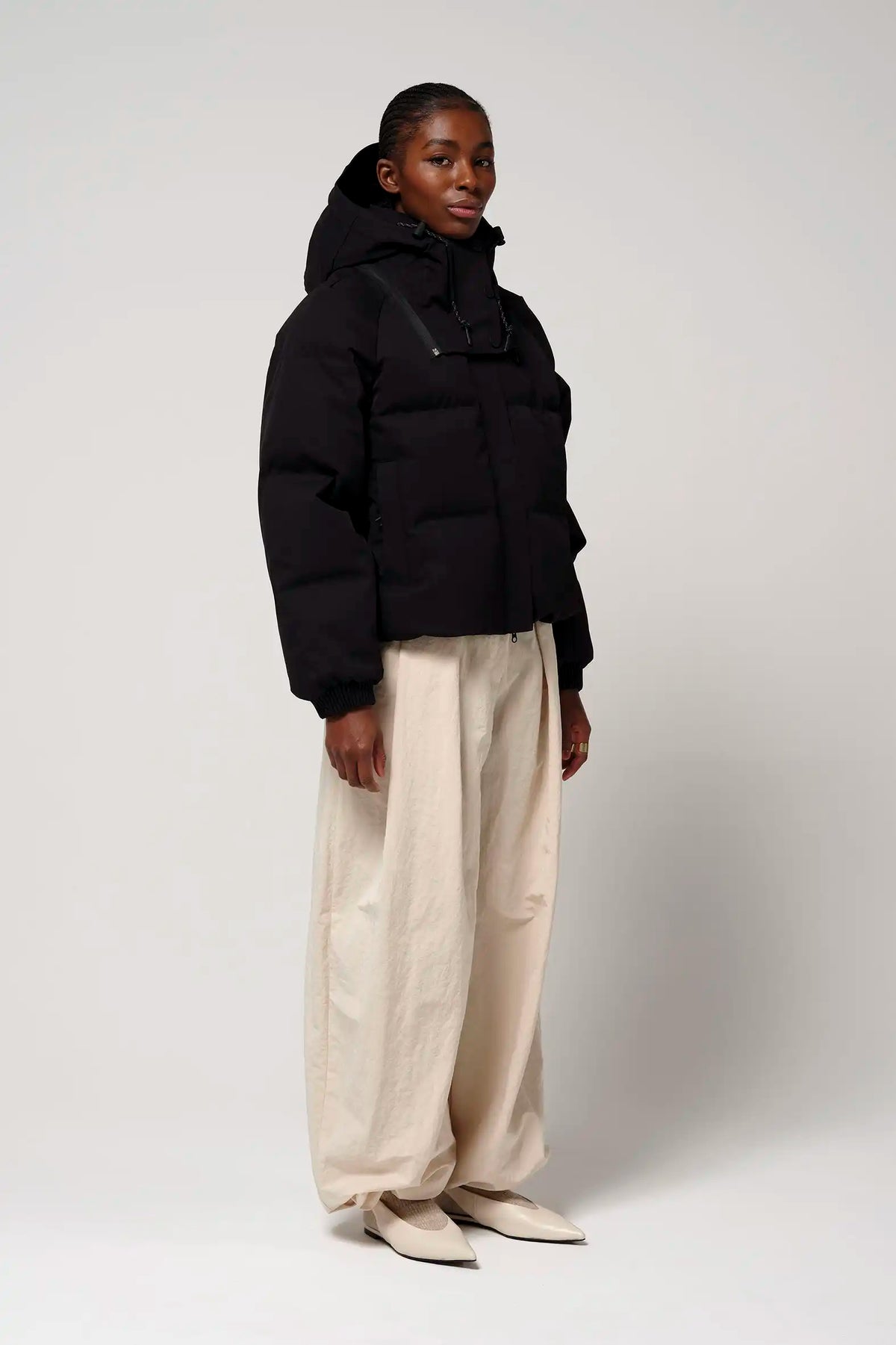 Model wearing Talon Deep Black Coat with removable hood and two-way zipper.