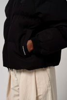 Model wearing Talon Deep Black Coat showcasing the removable hood and outer pocket details.