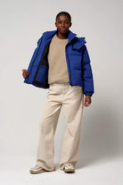 Model wearing the Talon Sodalite Blue Coat, a waterproof and windproof jacket with a removable hood.