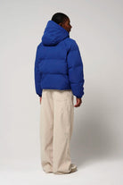 Woman wearing Talon Sodalite Blue Coat, showcasing the back with removable hood and puffy design.