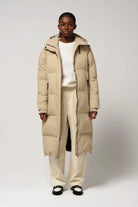 Model wearing Tsunami Fields of Rye Beige Coat, a lightweight waterproof puffer coat with a stylish design.