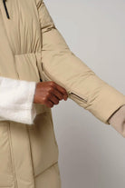 Model demonstrating sleeve zipper detail of Tsunami Fields of Rye Beige Coat, highlighting comfort features.