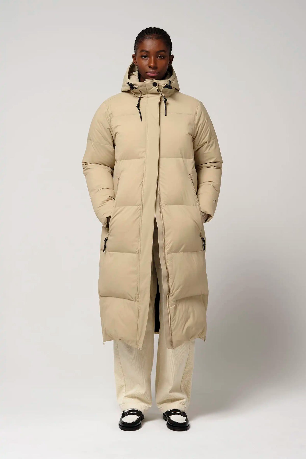 Tsunami Fields of Rye Beige Coat displayed on model, showcasing its lightweight, waterproof design and stylish fit.