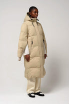 Model wearing Tsunami Fields of Rye Beige Coat, a lightweight waterproof puffer coat with stylish features.