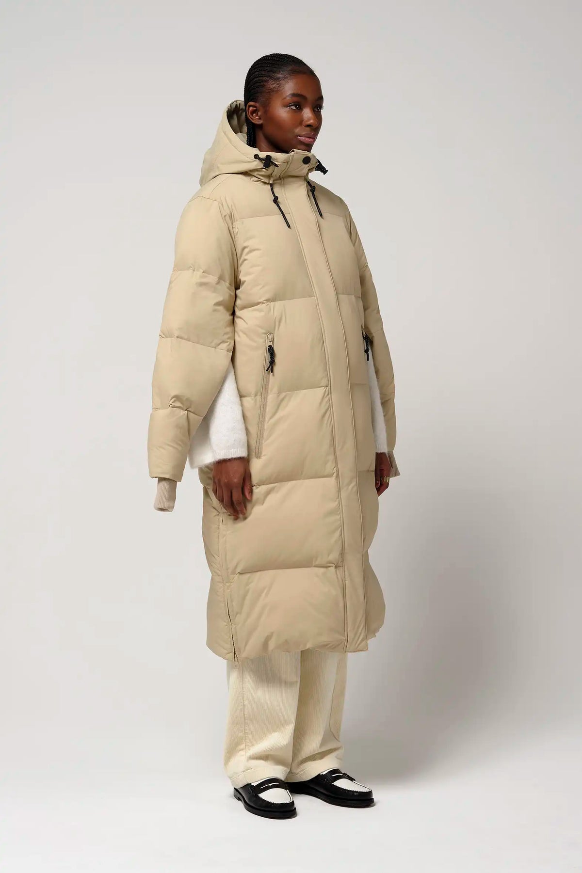 Model wearing Tsunami Fields of Rye Beige Coat, a lightweight waterproof puffer coat with stylish features.