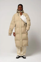 Model wearing Tsunami Fields of Rye Beige Coat, a lightweight waterproof puffer coat with stylish features.